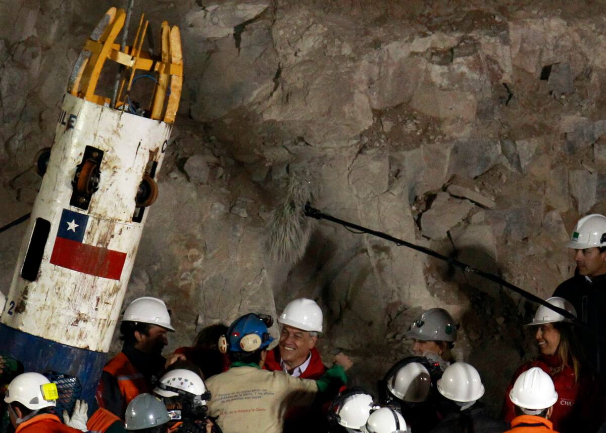 El presidente chileno, Sebastián Piñera, abraza al minero Raúl Bustos tras su rescate de la mina de oro y cobre colapsada de San José donde permaneció atrapado con otros 32 mineros por cerca de dos meses, cerca de Copiapo, Chile, el 13 de octubre de 2010. Piñera murió el 6 de febrero de 2024 en un accidente de helicóptero en Lago Ranco, Chile, según confirmó la ministra de Interior, Carolina Tohá en una intervención en televisión. (AP Foto/Jorge Sáenz, Archivo)