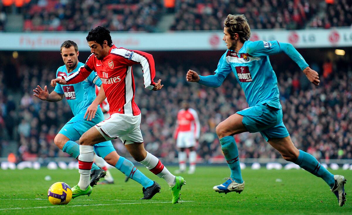 31/01/09 El jugador del Arsenal Carlos Vela trata de dejar atrás a los jugadores del West Ham Valon Behrami (d) y Lucas Neill (i) durante un partido de la Premier League inglesa en Londres, Inglaterra. El partido acabó 0-0. EFE/Andy Rain.
