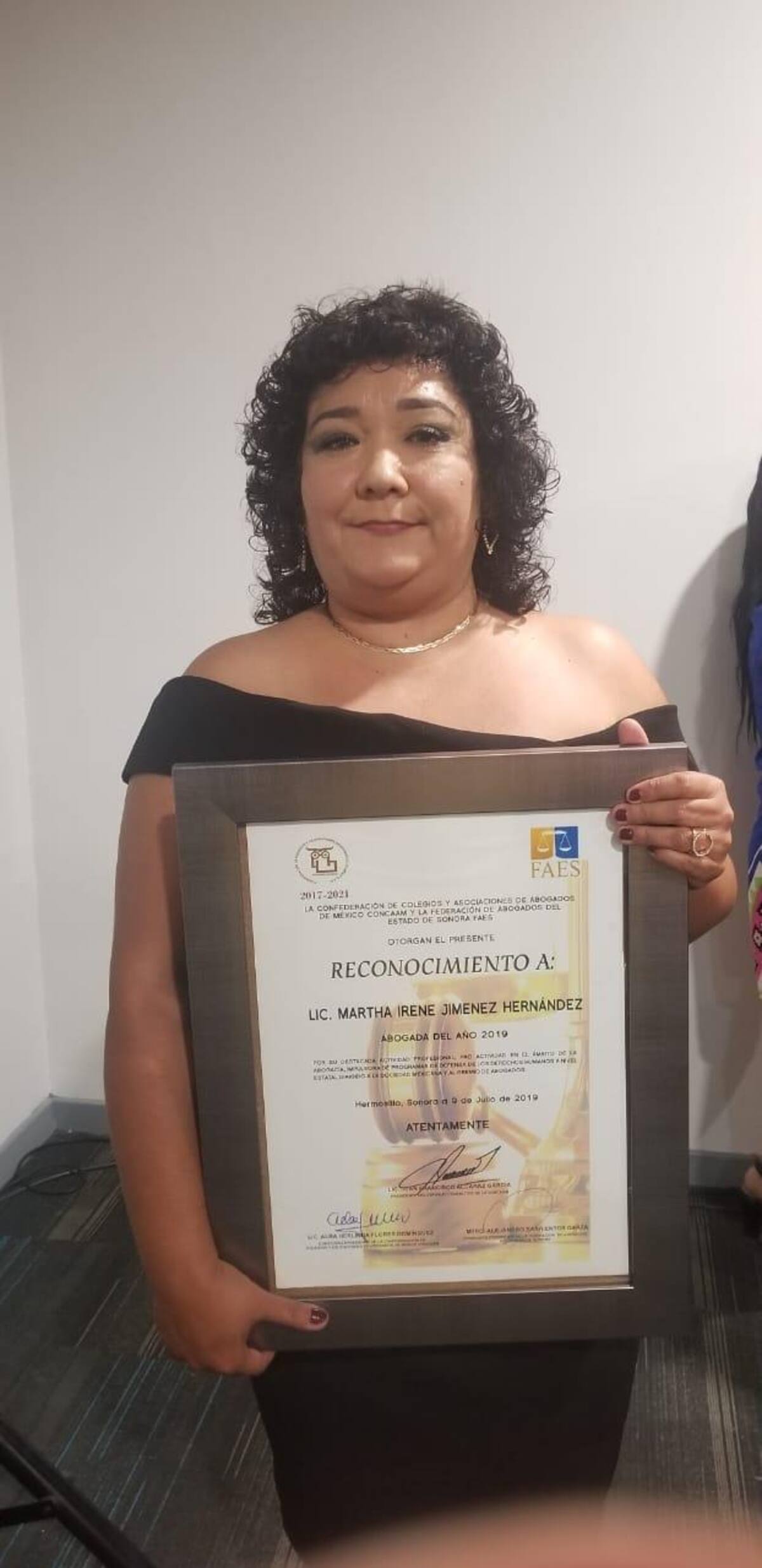 Martha Irene Jiménez posa con su reconocimiento.