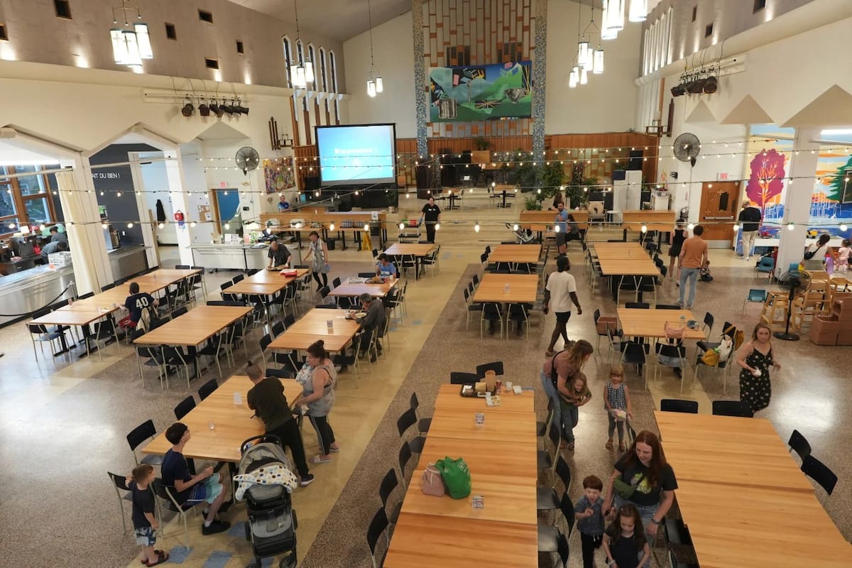 Familias y personal del restaurante Le Chic Resto Pop se reúnen tras cenar en la antigua iglesia católica Saint-Mathias-Apotre. | Crédito: AP/Luis Andres Henao)