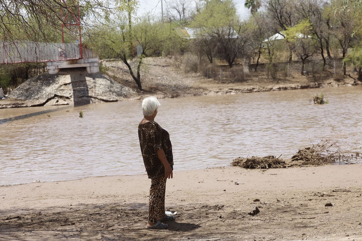 La señora Lourdes García, de 76 años, quien vive en San José de Gracia, en el Municipio de Hermosillo, observa el agua del Río Sonora.