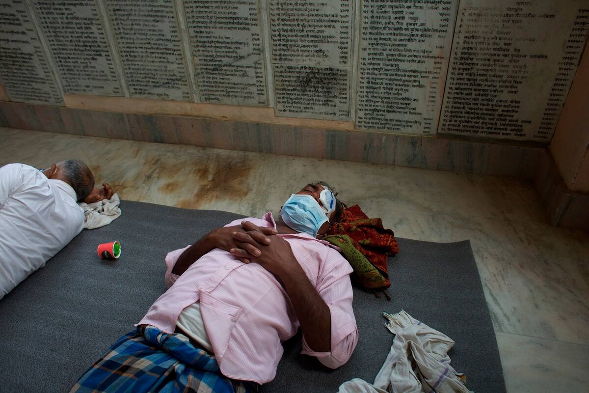 Un paciente descansa en el piso tras ser sometido a una operación de cataratas por el doctor Sanduk Ruit en Lumbini, Nepal, el 31 de marzo del 2021. (AP Photo/Bikram Rai)