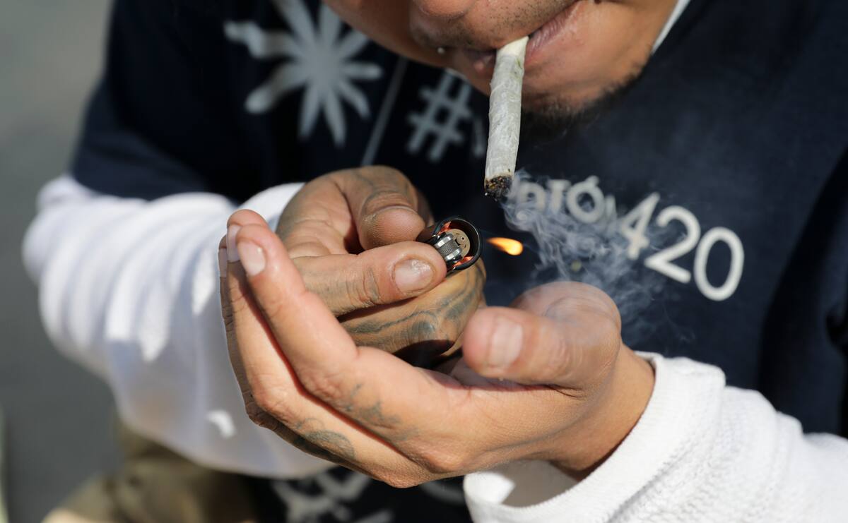 Un hombre enciende un cigarrillo de marihuana el jueves 19 de noviembre de 2020 en un campamento improvisado frente al Senado, en la Ciudad de México. (AP Foto/Eduardo Verdugo)
