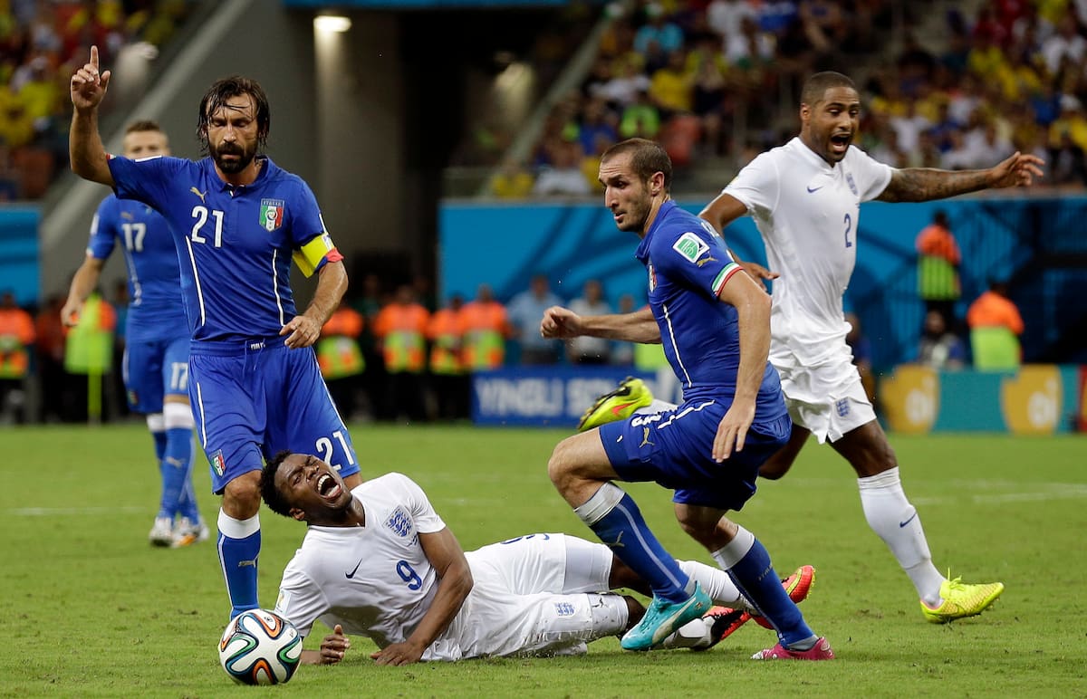 England's Daniel Sturridge, centre, grimaces alongside Italy's Andrea Pirlo, left, after being fouled during the group D World Cup soccer match between England and Italy at the Arena da Amazonia in Manaus, Brazil, Saturday, June 14, 2014. (AP Photo/Martin Mejia)