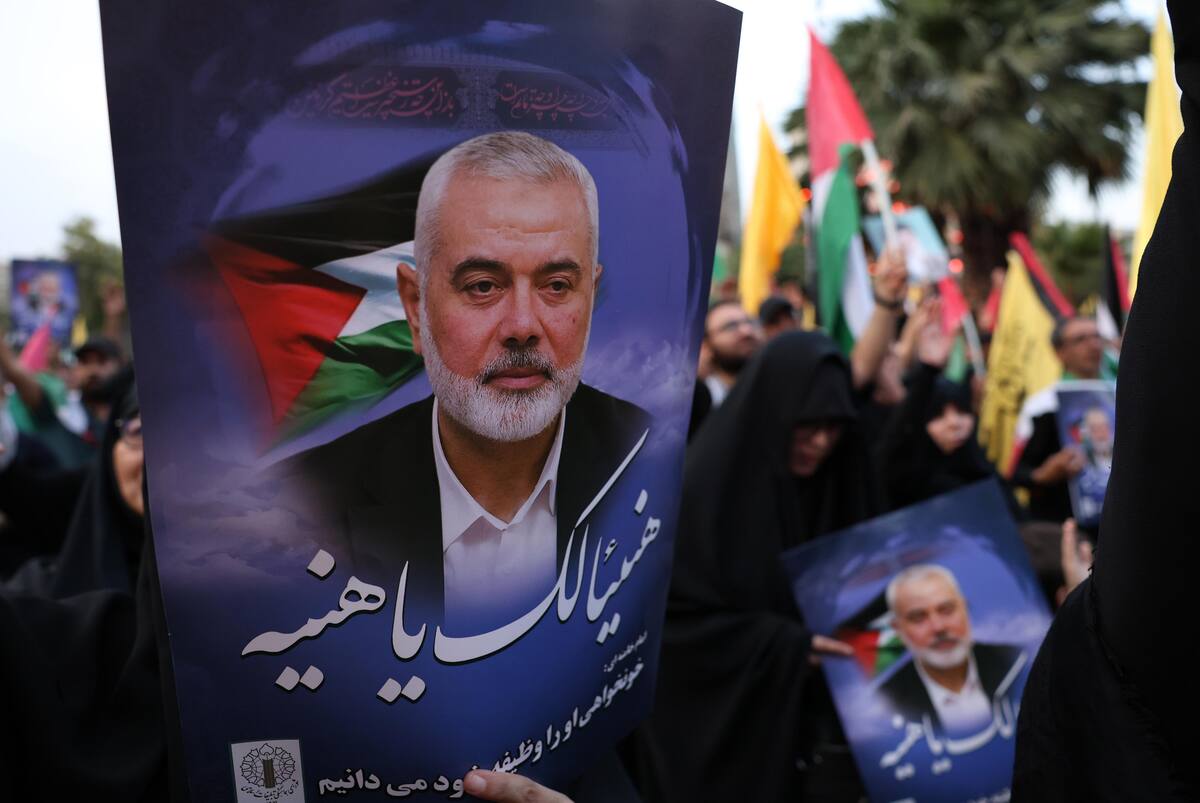 Ciudadanos iraníes protestan en Teherán, sosteniendo fotos del líder de Hamás, Ismail Haniyeh. Foto: EFE/EPA/ABEDIN TAHERKENAREH