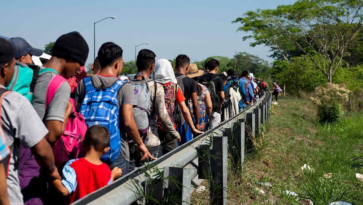 CORRECTS LOCATION - Central American migrants, part of a caravan hoping to reach the U.S. border, walk on the shoulder of a road in Frontera Hidalgo, Mexico, Friday, April 12, 2019. The group pushed past police guarding the bridge and joined a larger group of about 2,000 migrants who are walking toward Tapachula, the latest caravan to enter Mexico. (AP Photo/Isabel Mateos)