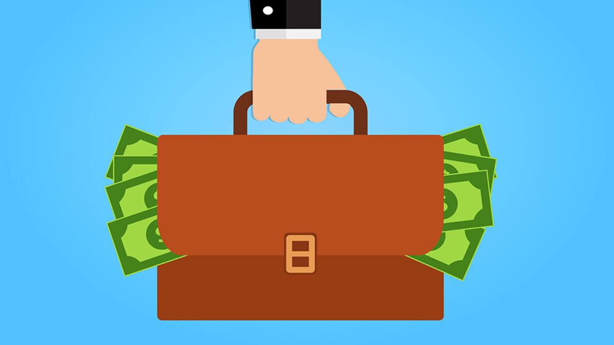 Businessman hand holding briefcase full of money