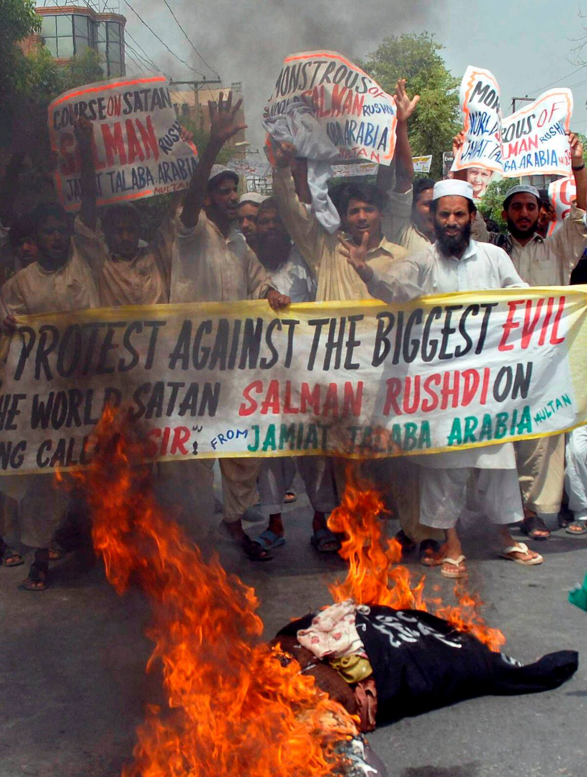 MTN01. MULTÁN (PAKISTÁN), 17/06/07.- Varios estudiantes miembros del partido religioso Jamiat Talba-e-Arabia queman una efigie del escritor Salman Rushdie durante una protesta realizada en Multán, Pakistán, el 17 de junio de 2007, por la concesión del título de caballero británico por la reina de Inglaterra, Isabel II, a este escritor angloindio, condenado a muerte por Irán en 1989 por su libro "Versos satánicos". EFE/MK CHAUDHRY