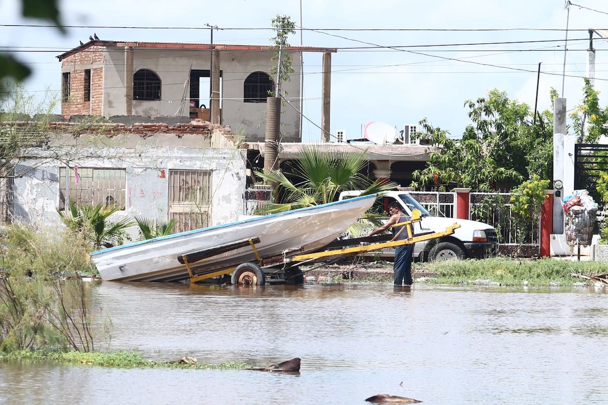 Una persona revisa una lancha en un área inundada de la colonia Bellavista; los vecinos del lugar toman sus precaucaciones.