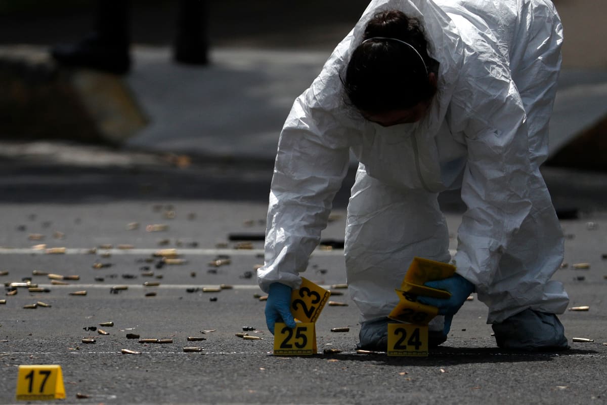 Personal forense marca los cartuchos percutidos en el lugar donde se registró un atentado contra el secretario de Seguridad Ciudadana de Ciudad de México, el viernes 26 de junio de 2020. (AP Foto/Rebecca Blackwell)
