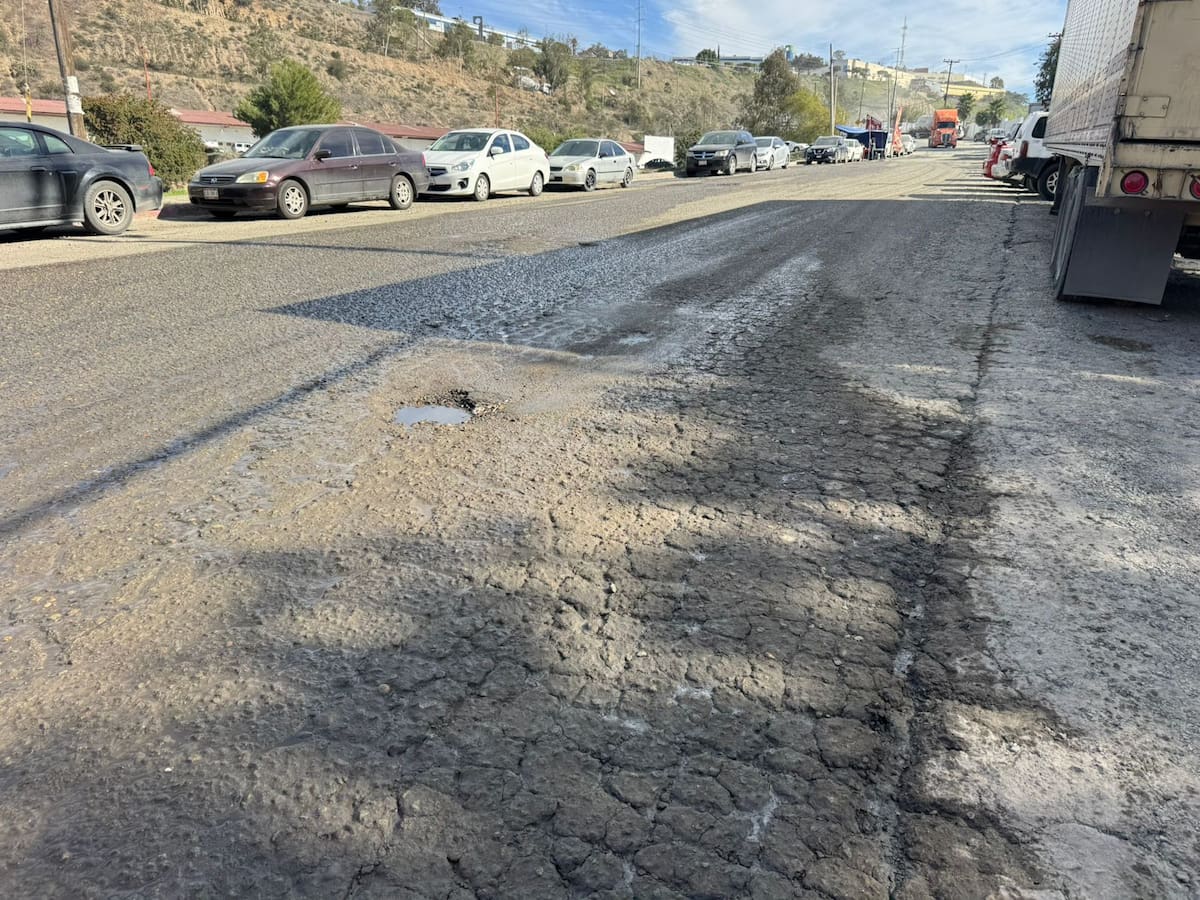 Vecinos y autoridades escolares denunciaron que unidades de carga bloquean la avenida, destruyen la vialidad y obligan a estudiantes a caminar entre tráileres y baches. Foto: Khennia Reyes