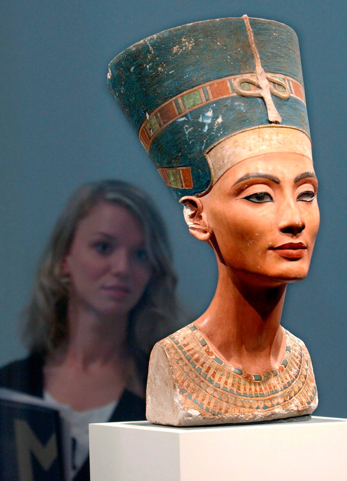 DPAI303 BERLÍN (ALEMANIA) 31.03.09 Fotografía de archivo con fecha del 12 de agosto de 2005 que muestra el busto de la reina Nefertiti, en el Museo Antiguo de Berlín (Alemania). Investigadores alemanes han descubierto recientemente que el busto de la reina egipcia, considerada la mujer más bella del mundo, en realidad tiene dos caras. La revista 'Radiology' ha publicado hoy, 31 de marzo de 2009, que este hallazgo ha sido posible gracias a una sofisticada técnica de escaneo. Los investigadores encontraron una cara finamente tallada en piedra caliza bajo la otra visible de estuco. 'El rostro interno de Nefertiti no es anónimo, pues está firmado por el escultor real Thutmose', asegura el director del instituto que ha llevado a cabo la investigación, el Dr. Alexander Huppertz. El estudio muestra que Thutmose colocó varias capas de diverso grosor sobre el perfil de piedra caliza para resaltar algunos de los rasgos de la Reina. EFE/Stephanie Pilick