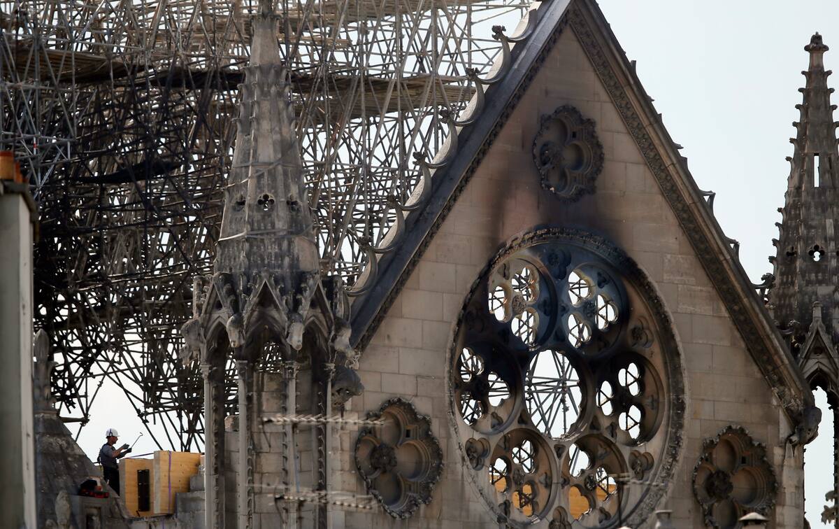 A worker checks on a wooden support structure placed on the Notre Dame Cathedral in Paris, Wednesday, April 17, 2019. Nearly $1 billion has already poured in from ordinary worshippers and high-powered magnates around the world to restore Notre Dame Cathedral in Paris after a massive fire. (AP Photo/Francois Mori)