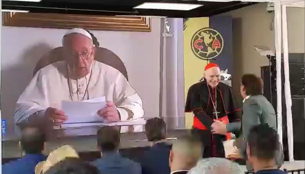 El cardenal, Carlos Aguiar Retes, saluda de mano al propietario del Club América, Emilio Azcárraga. Al fondo la proyección de un video del Papa Francisco felicitando al equipo. (Foto: Redes sociales)
