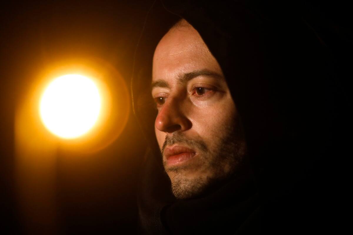 El activista y artista brasileño Rafael Puetter, disfrazado de la Parca, conversa con AP antes de su protesta solitaria frente a la Puerta de Brandeburgo la madrugada del miércoles 7 de abril de 2021 en Berlín. (AP Foto/Markus Schreiber)