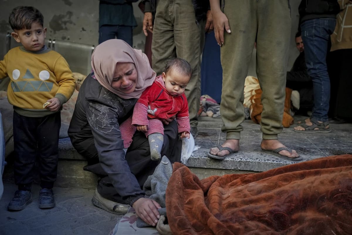 Una mujer llora junto a un cuerpo tras el ataque masivo de Israel en Gaza el 18 de marzo del 2025. | Crédito: AP
