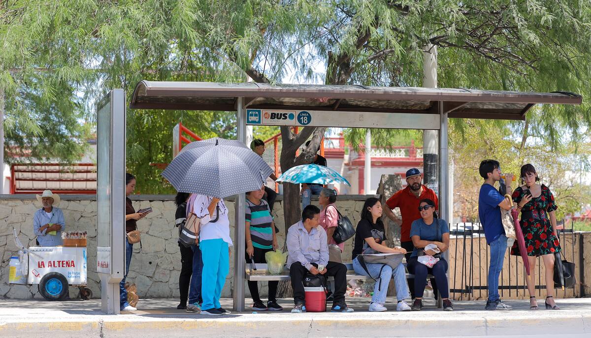 Un grupo de personas se resguarda en una parada del camión de los
intensos rayos del Sol. FOTO: GERARDO GONSÁLEZ