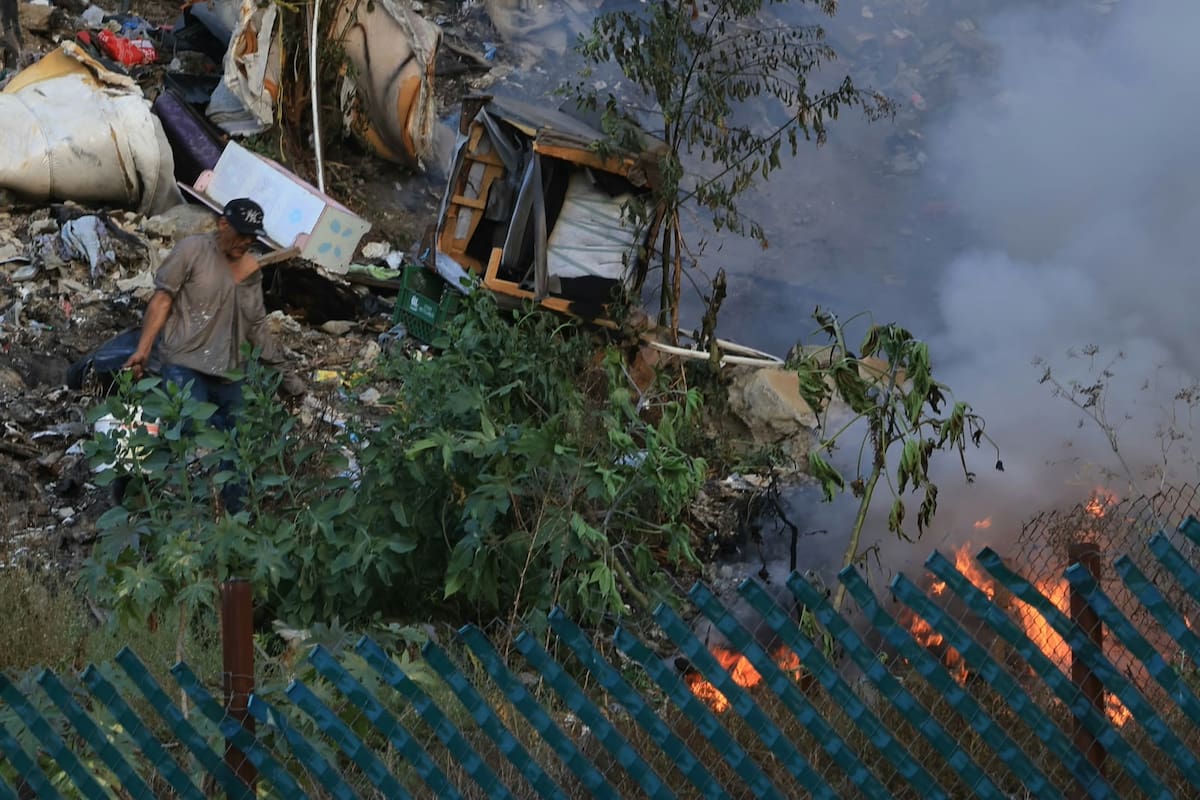 Un hombre en situación de calle sofocó con cubetas de agua un incendio de basura en la colonia Anexa Buena Vista, en Tijuana. Foto: Sergio Ortiz