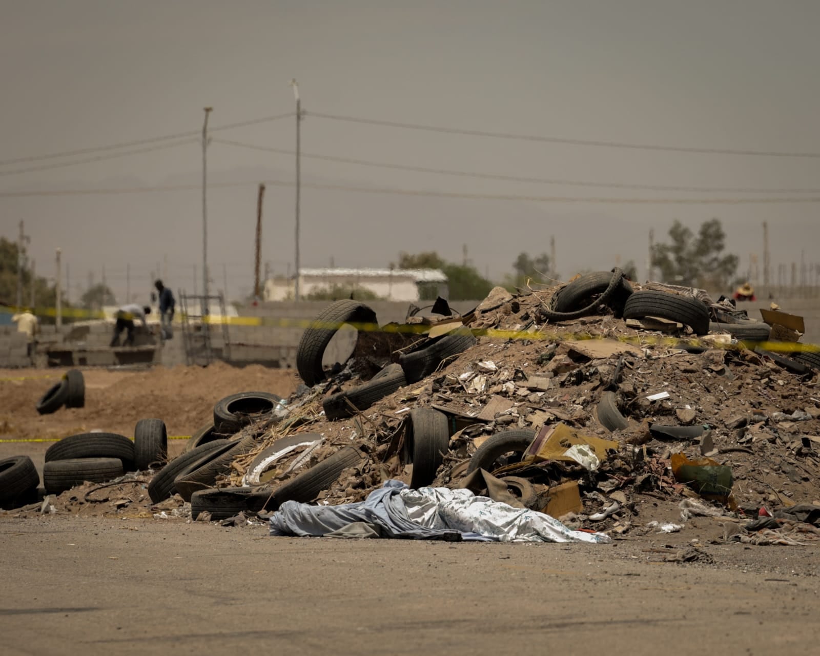 Personal de la Fiscalía General del Estado realiza diligencias tras el hallazgo del cuerpo de un joven localizado con las manos atadas y envuelto en una cobija cerca del cuartel de la Guardia Nacional, en la zona poniente de Mexicali. (Foto: Javier Gallegos)