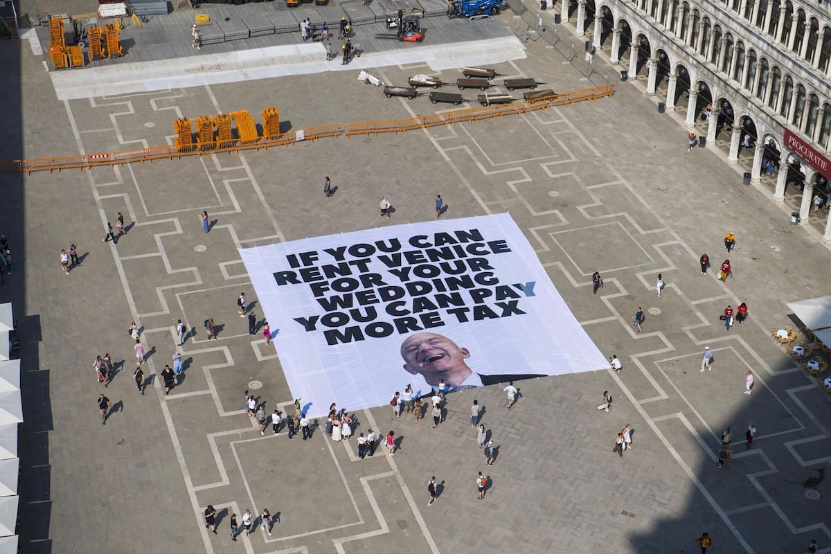Una enorme pancarta de 400 metros cuadrados fue desplegada este lunes en la Plaza de San Marcos de Venecia por activistas que protestaban contra el multimillonario estadounidense Jeff Bezos, en el marco de su inminente boda con la expresentadora Lauren Sánchez. | Crédito: EFE/EPA/GREENPEACE PRESS OFFICE HANDOUT HANDOUT EDITORIAL USE ONLY/NO SALES