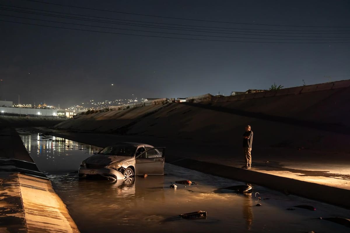 El conductor, de unos 65 años, resultó ileso tras caer con su auto al cauce de agua. Foto: Border Zoom