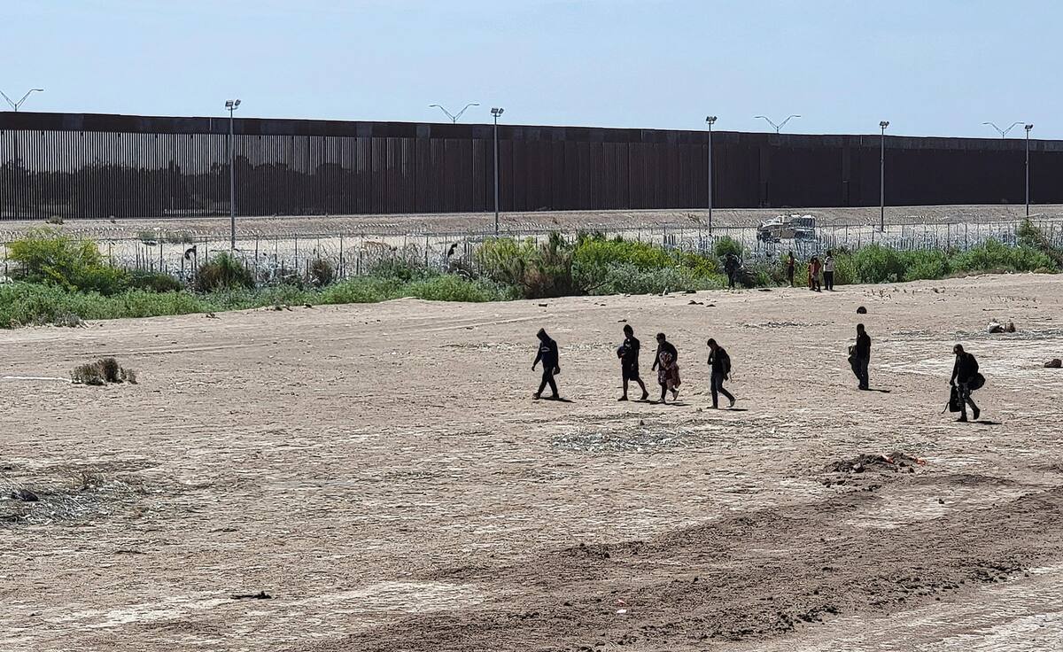 Foto de archivo de migrantes caminando por una orilla de la línea divisoria entre México y EU, en Ciudad Juárez, Chihuahua. | EFE/ Luis Torres