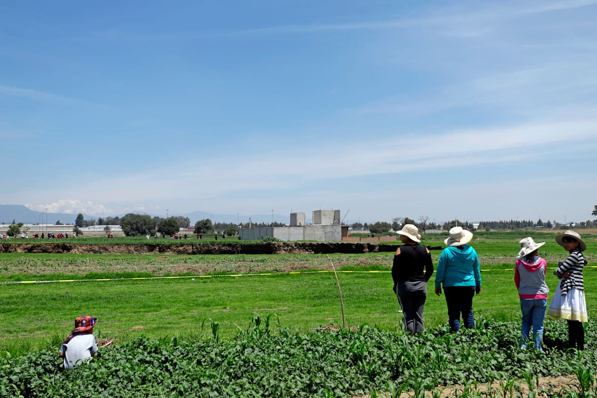 Un grupo de mujeres observa, el enorme socavón, en la zona de cultivo la loma, del municipio de Juan C. Bonilla estado de Puebla (México). EFE/Hilda Ríos