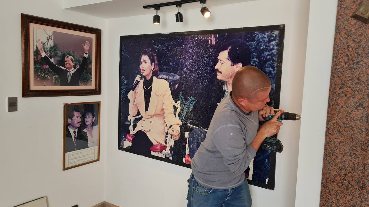 José Alejandro Cáñez se encarga de pintar y colocar de nuevo los cuadros de Luis Donaldo Colosio en el Mausoleo de Magdalena, Sonora. FOTO: JULIÁN ORTEGA