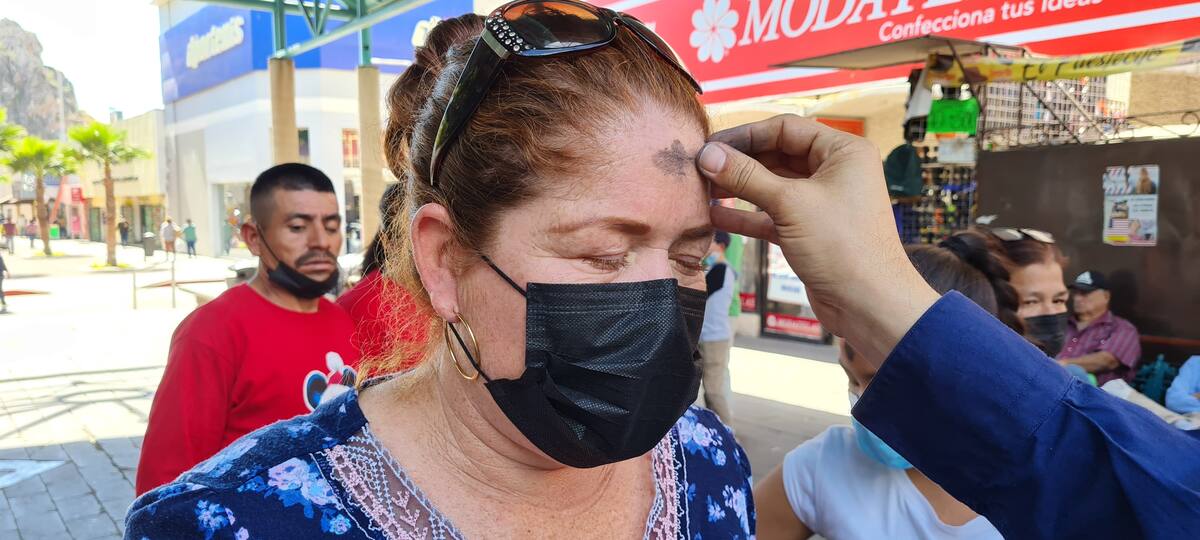 Fotografía de una mujer recibiendo la ceniza en su frente.