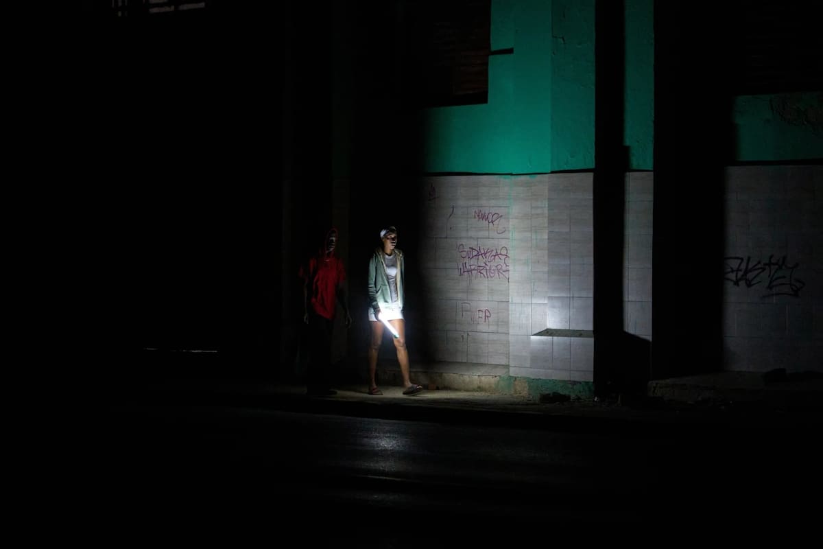 Personas caminan por una calle durante un apagón en La Habana, Cuba, el sábado 21 de marzo de 2026. | Crédito: AP/Ramon Espinosa