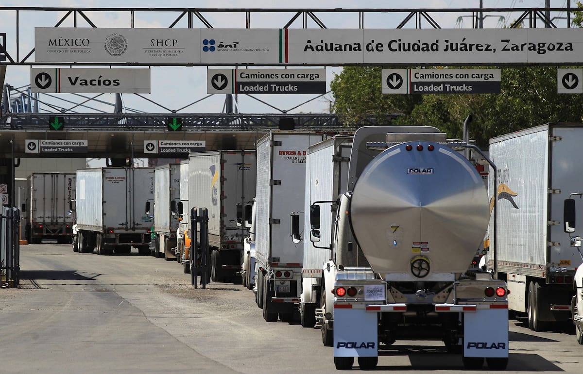 Fotografía de archivo de conductores de camiones que hacen fila para cruzar a Estados Unidos, en el puente Internacional Zaragoza, en la fronteriza Ciudad Juárez (México). EFE/Luis Torres