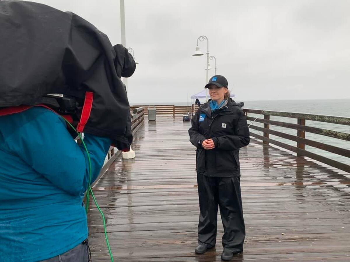 Molly McCollum transmitiendo desde un muelle sobre las condiciones climáticas. | Facebook/ wxmolly