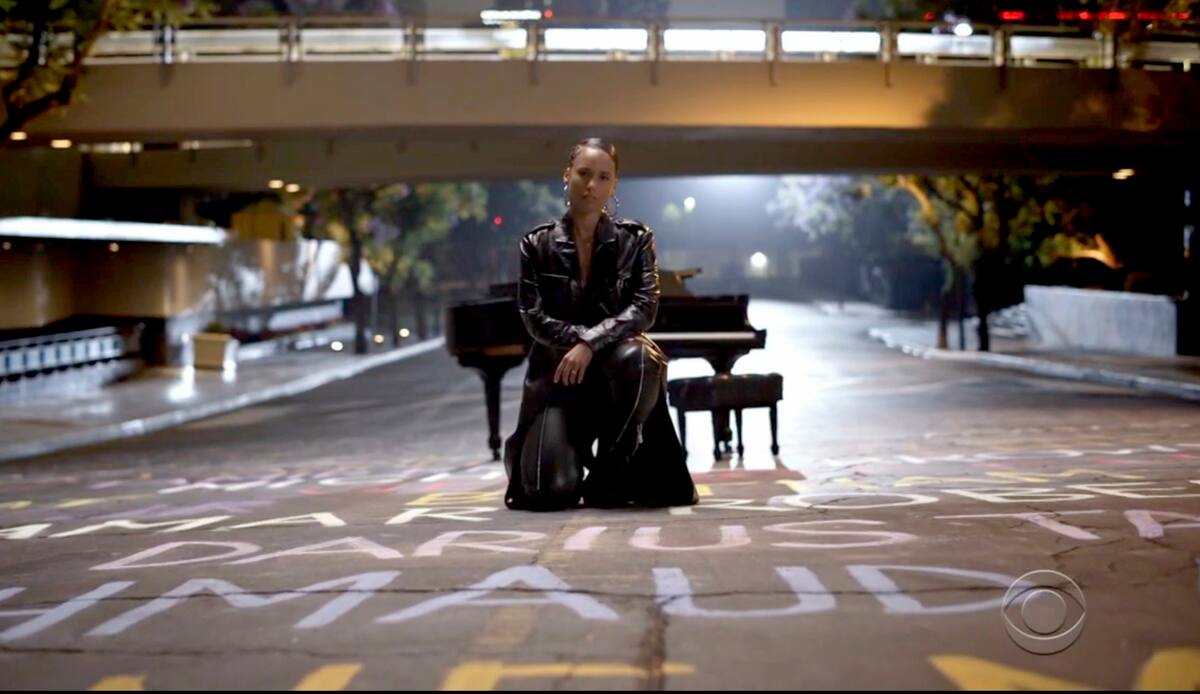 En esta imagen capturada de video emitida el domingo 28 de junio de 2020 por BET, Alicia Keys hincada sobre nombres de vidas negras perdidas durante la ceremonia virtual de los Premios BET. (BET vía AP)