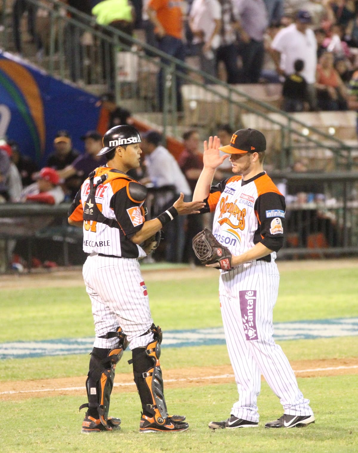 El receptor Erick Rodríguez felicita al cerrador Ryan Brasier por otro juego salvado con los Naranjeros de Hermosillo durante la temporada 2012-2013.