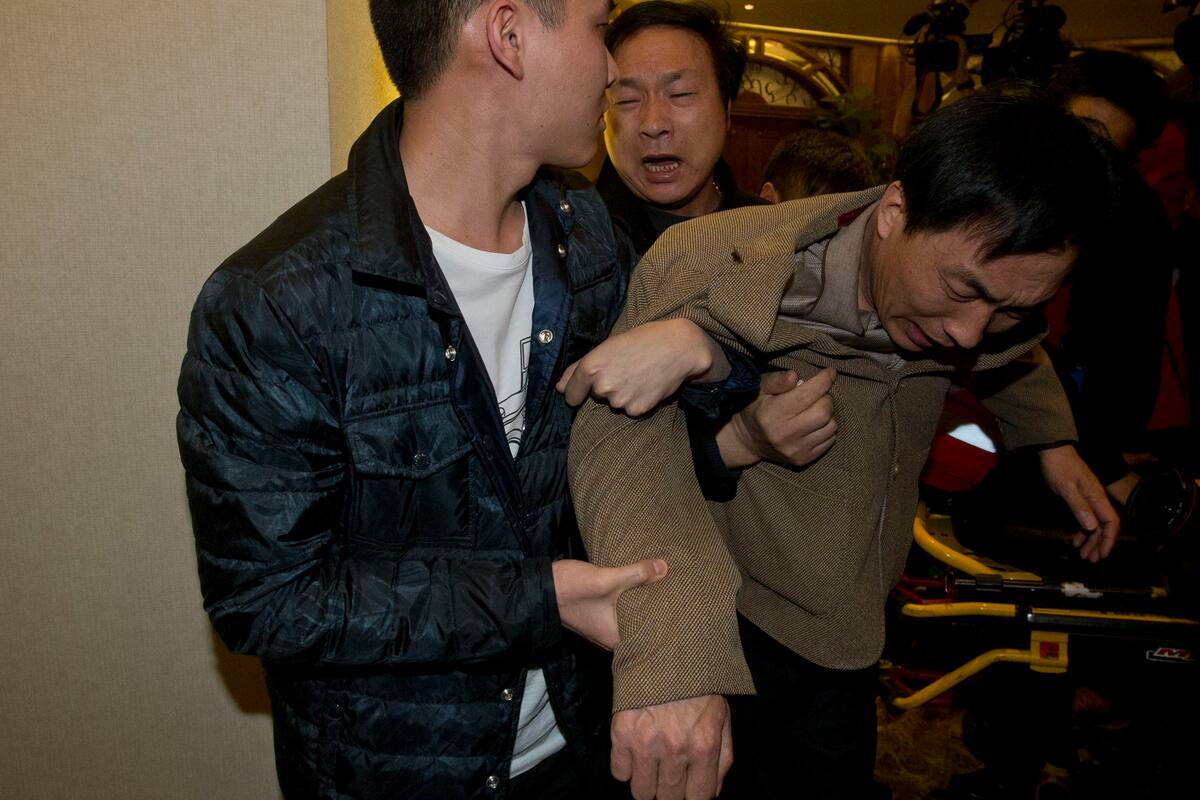 Familiares de un pasajero chino a bordo del MH370 de Malaysia Airlines, lloran después de enterarse de la última actualización en Beijing, China, el lunes 24 de marzo de 2014. Foto: AP