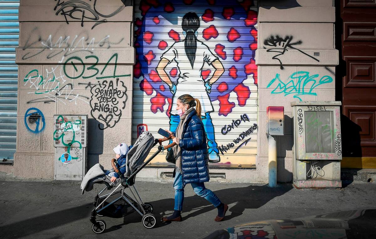 -FOTODELDIA- Milán (Italia) 28/02/2021.- Una viandante pasa delante de una obra de arte urbano que muestra a un trabajador sanitario frente al Covid-19 este domingo en Milán (Italia). EFE/ANDREA FASANI