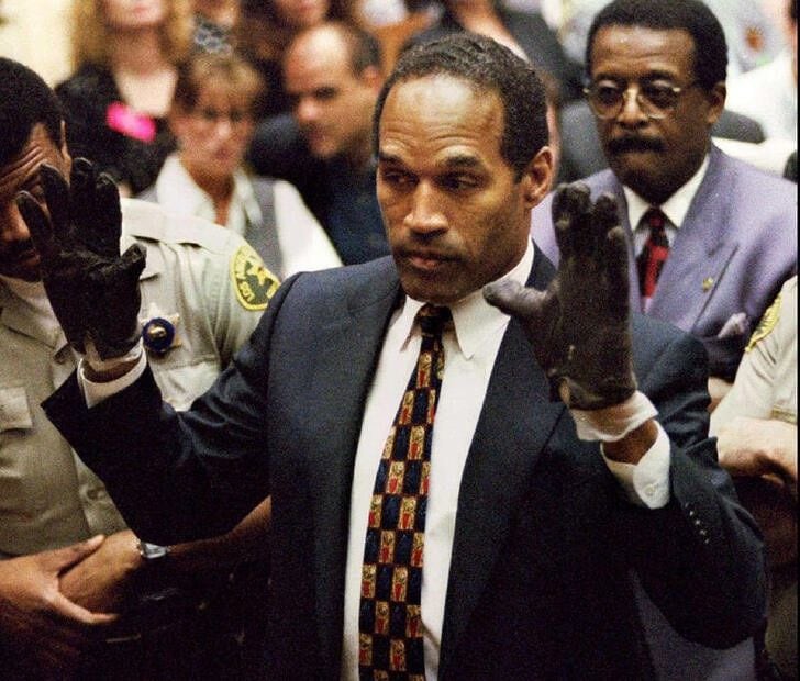 FOTO DE ARCHIVO: O.J. Simpson, con los guantes manchados de sangre encontrados por la Policía de Los Ángeles e introducidos como prueba en el juicio por asesinato de su exesposa, muestra sus manos al jurado a petición del fiscal Christopher Darden 
15 de junio de 1995
REUTERS/Sam Mircovich/