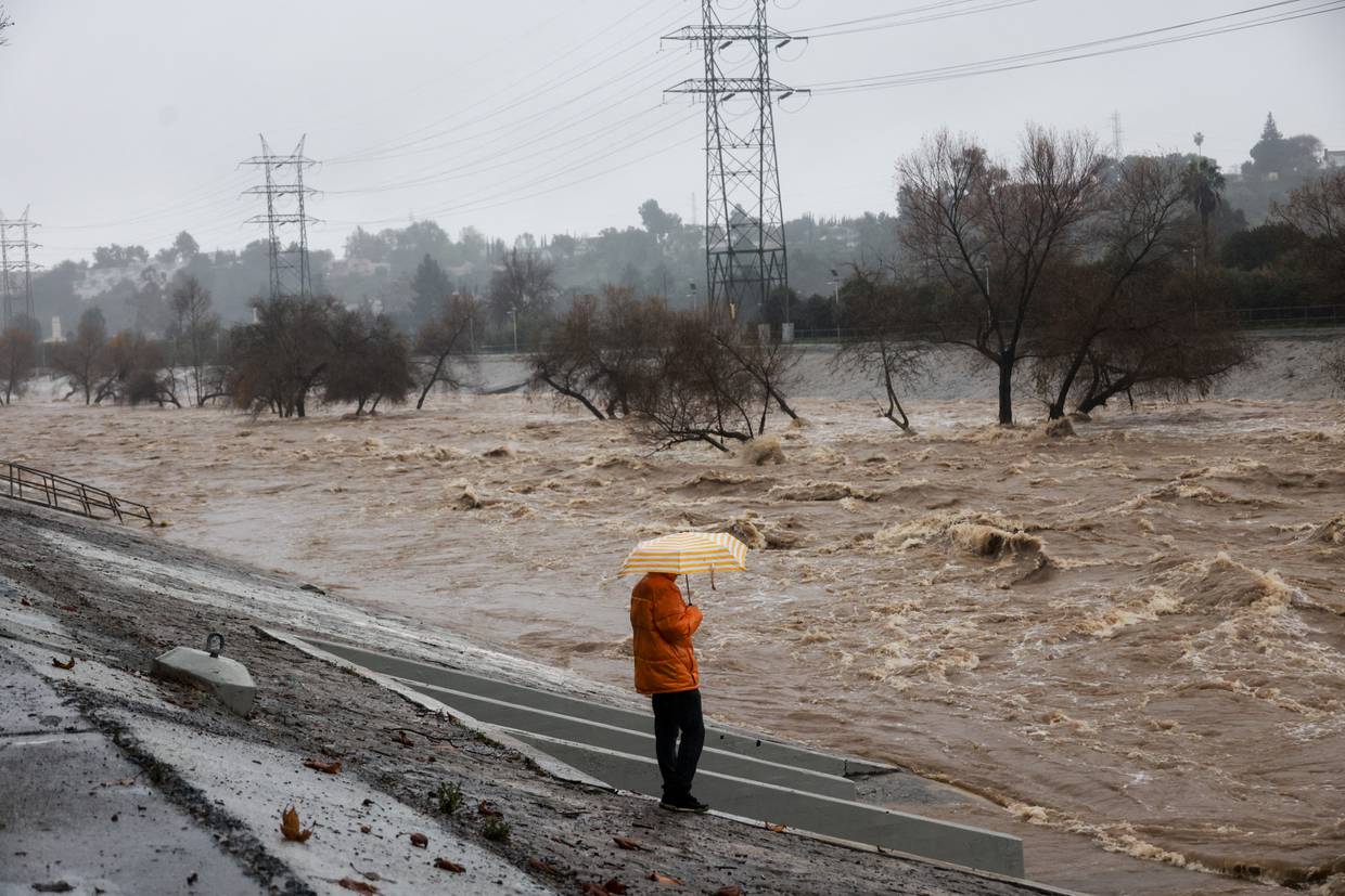 FOTO DE ARCHIVO. Una persona con un paraguas en la mano observa el río de Los Ángeles durante las fuertes lluvias en Los Ángeles, California, EEUU. 5 de febrero de 2024. REUTERS/Aude Guerrucci