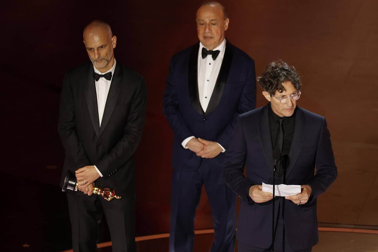 James Wilson (i), Leonard Blavatnik (c) y Jonathan Glazer (d), recibe el Óscar a mejor película internacional gracias a 'The Zone of Interest', este 10 de marzo de 2024, durante la edición 96 de los Premios de la Academia. EFE/ Caroline Brehman