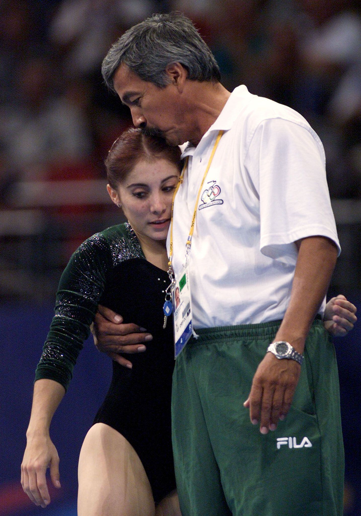 Mexican gymnast Denisse Lopez is embraced by coach Eduardo Carmona after her performance in the women's individual apparatus vault competition at the Olympic Games in Sydney, September 24, 2000. Lopez finished in eighth position behind gold medalist Elena Zamolodtchikova of Russia, silver medalist Andreea Raducan of Romania and bronze medalist Ekaterina Lobazniouk of Russia.     REUTERS/Mike Blake