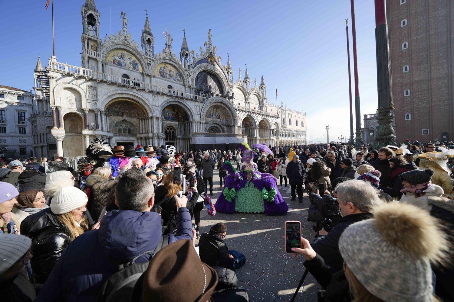 Una mujer ataviada con una máscara posa delante de la iglesia de San Marcos durante el Carnaval, en Venecia, Italia.