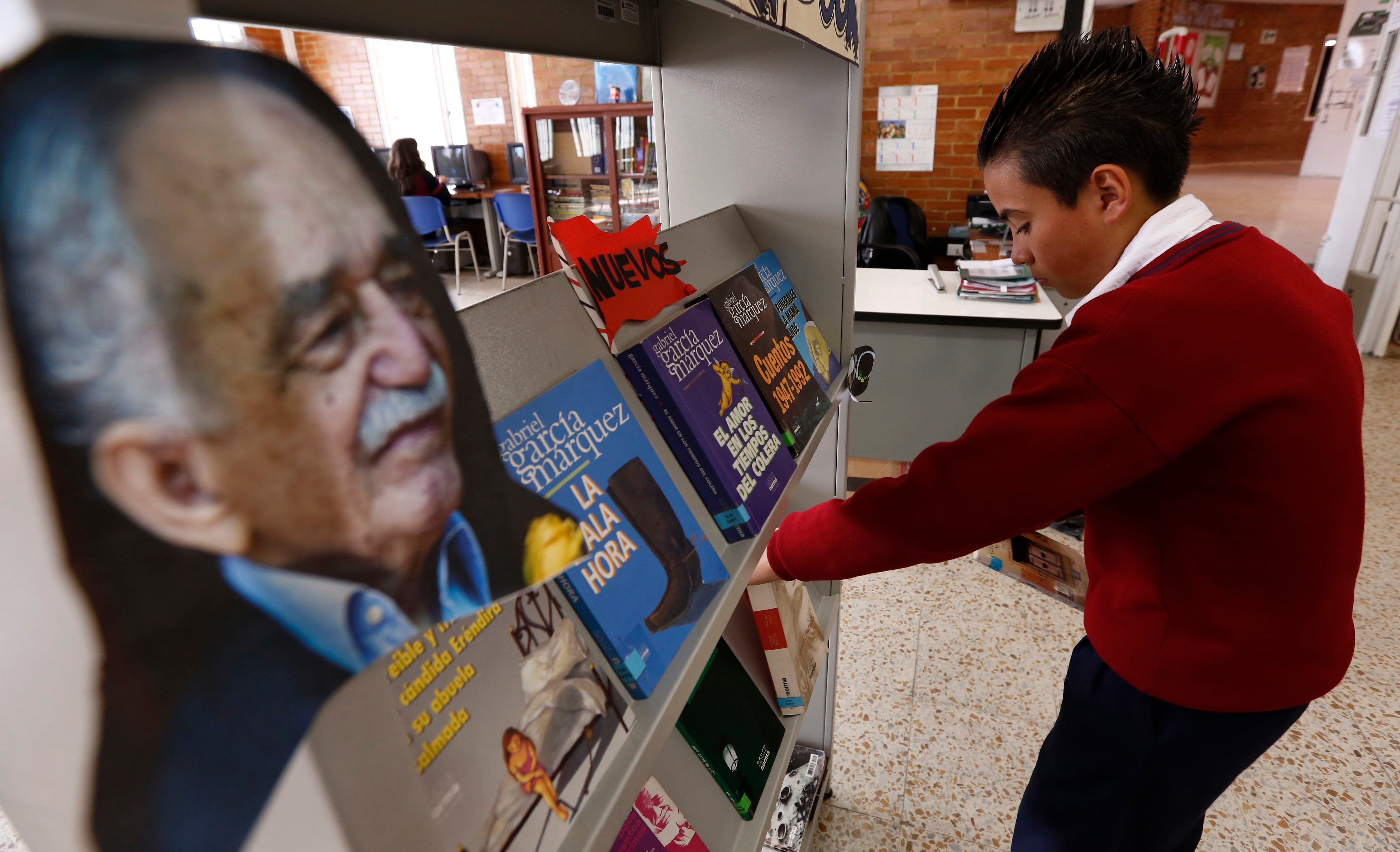 A student organizes books of the late Colombian Nobel Literature laureate Gabriel Garcia Marquez at a school in Bogota, Colombia, Wednesday, April 23, 2014. Colombia's Culture Ministry is promoting a marathon reading of Garcia Marquez's books across Colombia in honor of the author who died in Mexico City on April 17, 2014. (AP Photo/Fernando Vergara)
