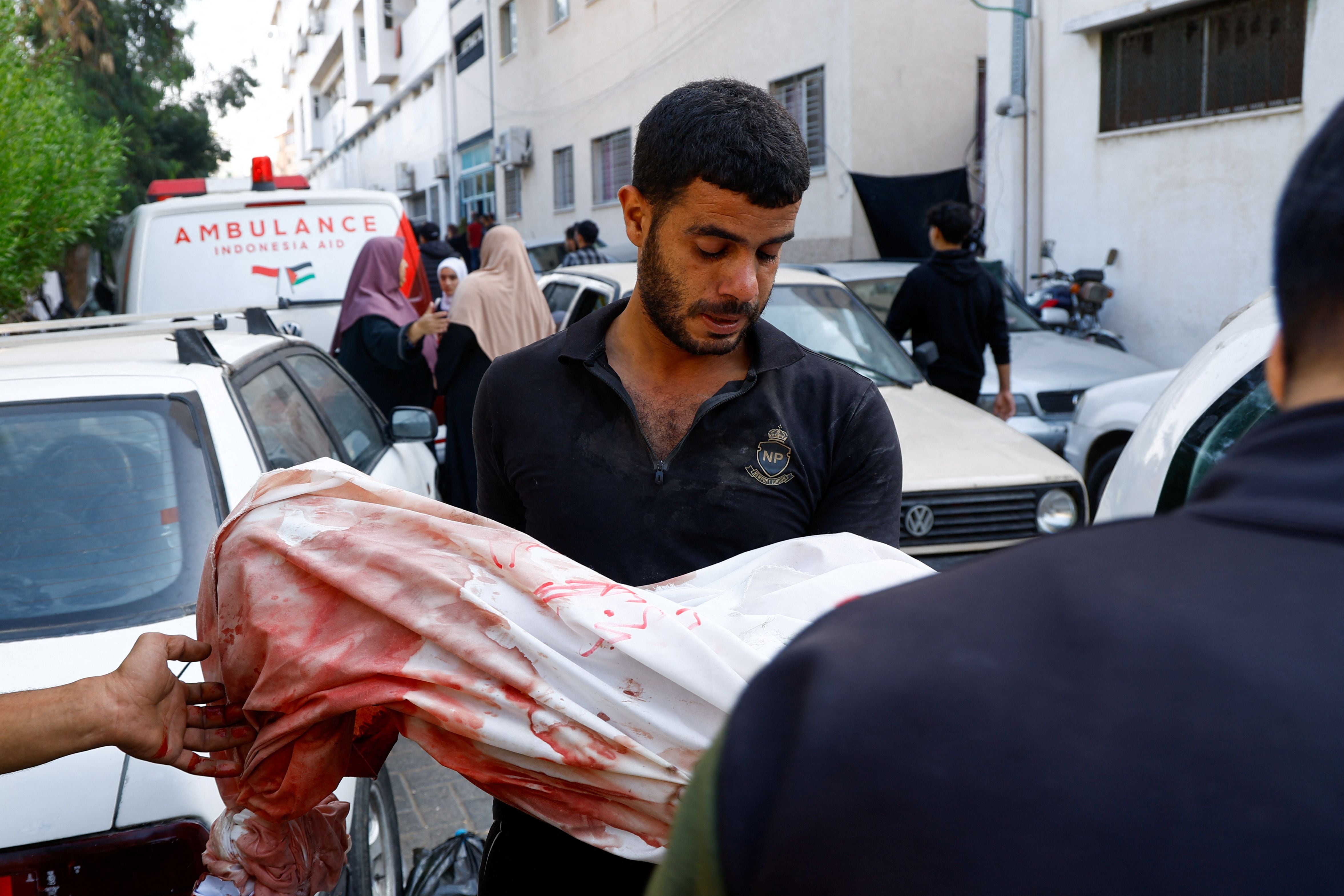 MATERIAL SENSIBLE. ESTA IMAGEN PUEDE OFENDER O MOLESTAR. Un palestino lleva el cuerpo de un niño muerto en ataques israelíes, en el hospital al-Shifa de la ciudad de Gaza, 12 de octubre de 2023. REUTERS/Mohammed Salem
