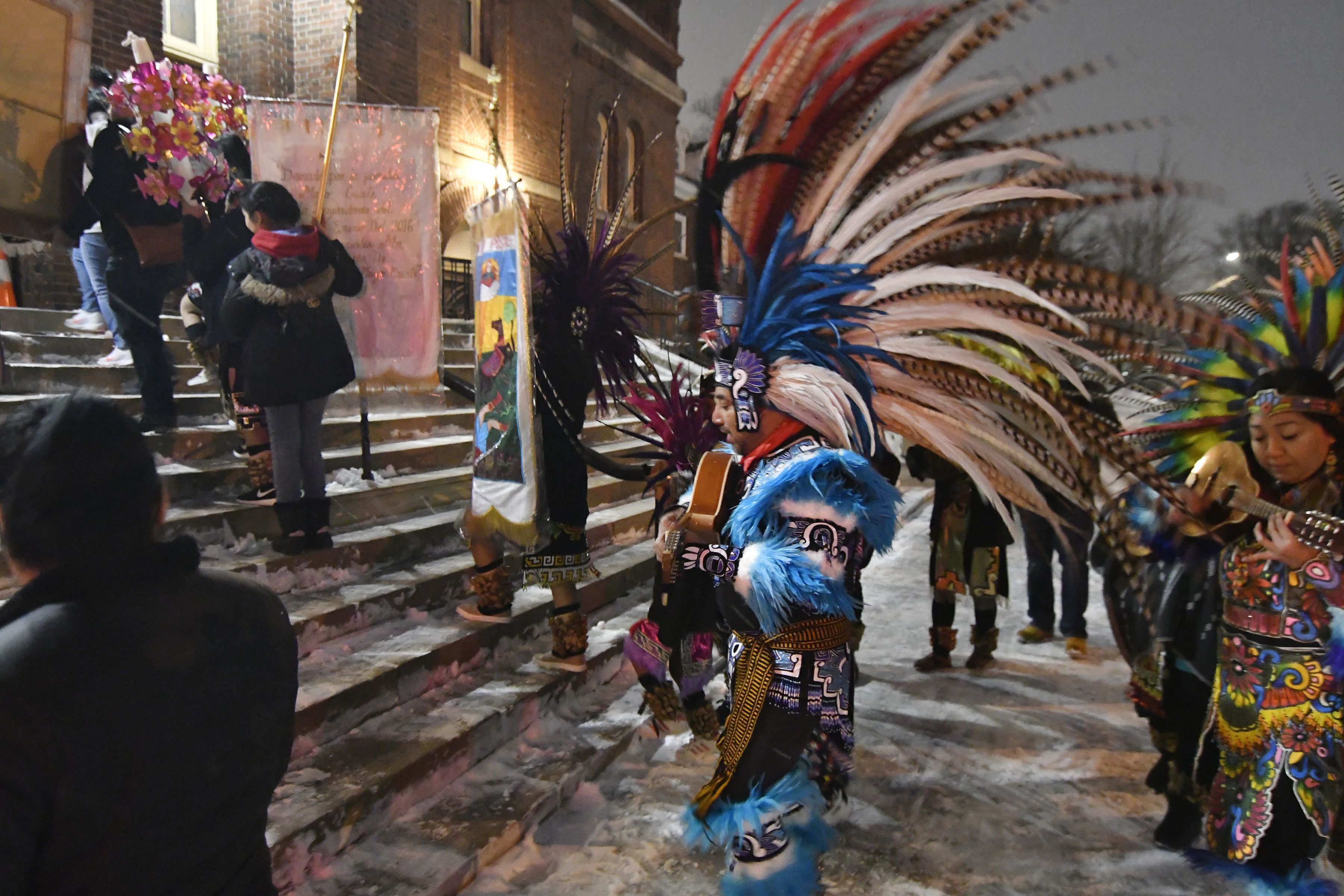 Personas con indumentarias aztecas tradicionales suben la escalinata de la Iglesia del Sagrado Corazón de Jesús en Minneapolis el 24 de enero del 2020, durante dos días de festejos en homanaje a San Pablo, santo patrono de Axochiapán, la localidad del sur de México de donde provienen muchos de los mexicanos que residen en Minneapolis. (AP Photo/Jim Mone)
